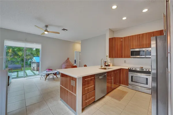 a kitchen that has a sink a stove and chairs in it