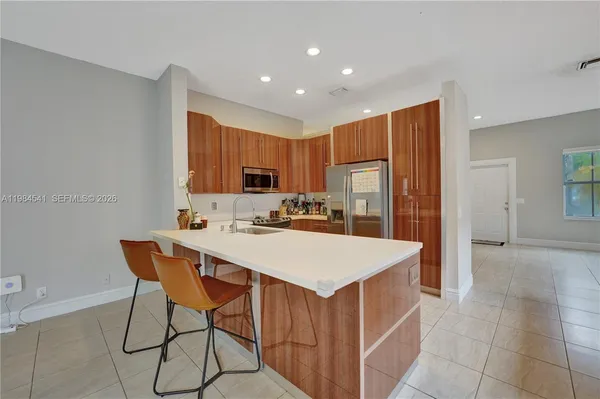 a kitchen with a sink a stove a refrigerator a dining table and chairs