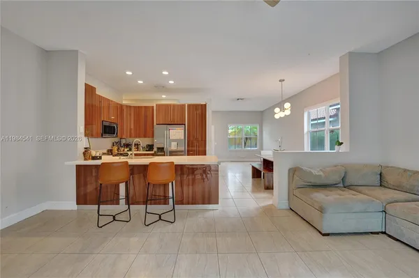 a living room with couches and kitchen view with wooden floor