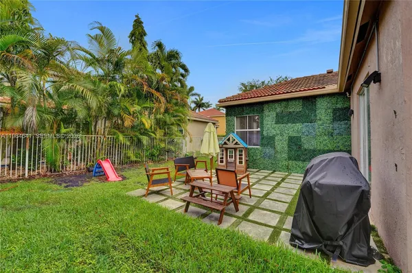a backyard of a house with table and chairs