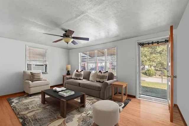 a living room with furniture a table and a large window