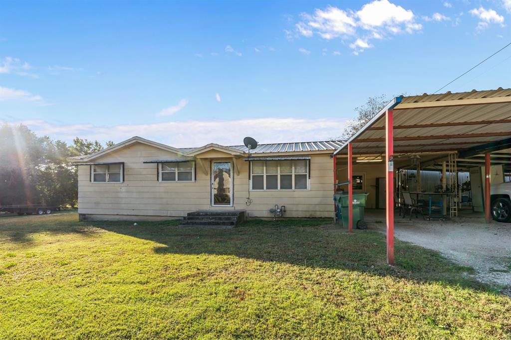 205 College Street Chico, TX 76431 - Photo 2 of 40 View of front of property with a front yard, a carport, and a metal roof