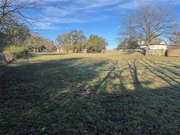 a view of a yard with a house in the background