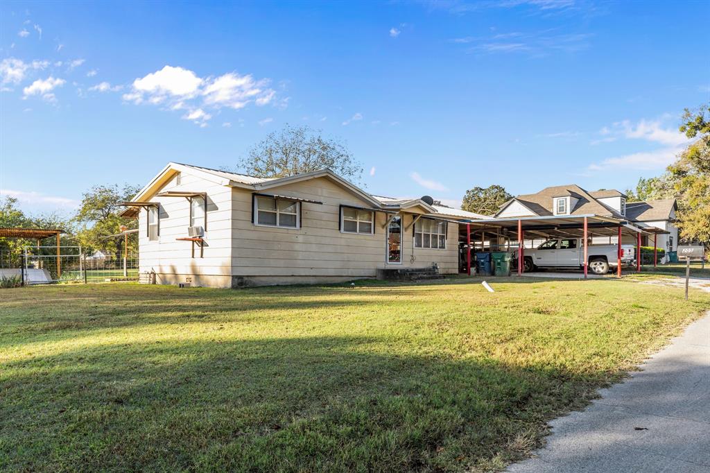 205 College Street Chico, TX 76431 - Photo 5 of 40 a front view of a house with a garden and swimming pool