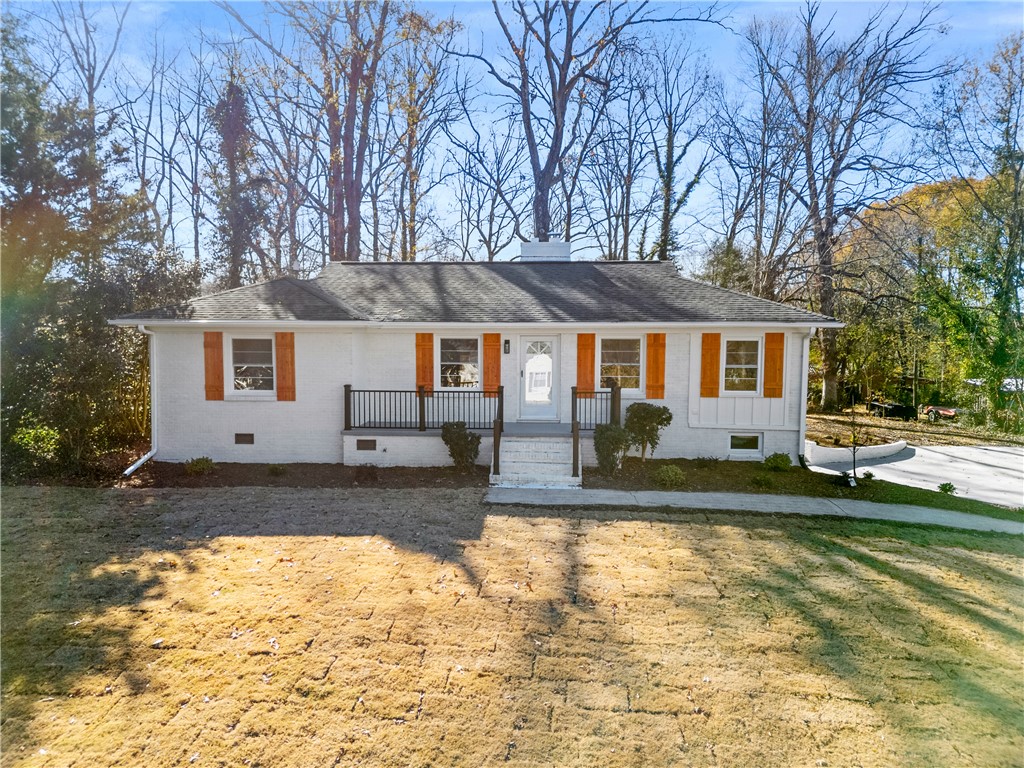 A classic ranch exterior showcases painted brick, natural wood shutters, and a welcoming front porch.