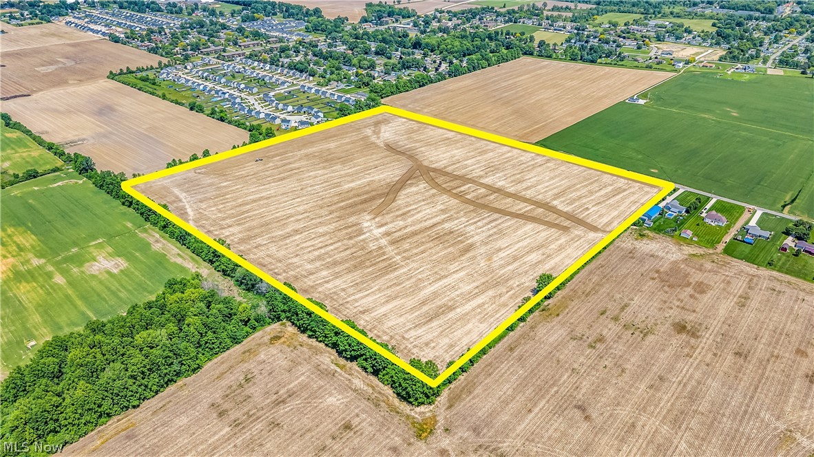 Fowl Road Elyria, OH 44035 - Photo 2 of 10 Expansive agricultural land featuring a tilled field with established tree lines bordering sections of the property