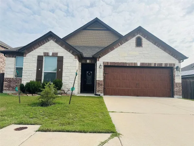 a front view of a house with a yard and garage