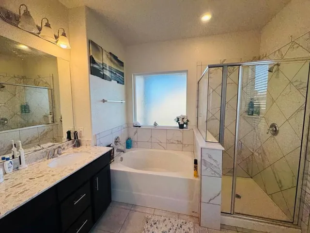 a bathroom with a bathtub and a double vanity sink