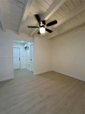 an empty room with ceiling fan and window