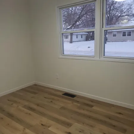 a view of a small space with wooden floor and a window