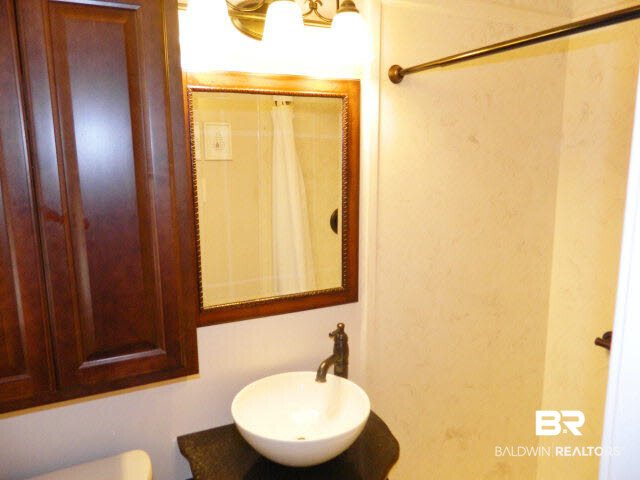 5008 Aldebaran Way West Mobile, AL 36693 - Photo 11 of 13 Custom marble walk in shower and beautiful wood vanity with unique round lavatory and bronze fixtures