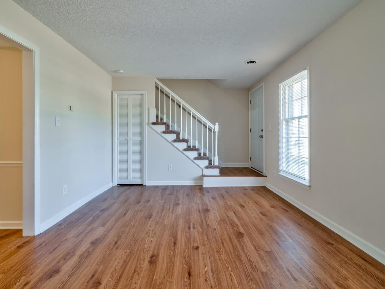 2220 New Hope Church Road Raleigh, NC 27604 - Photo 4 of 30 a view of an empty room with wooden floor and a window