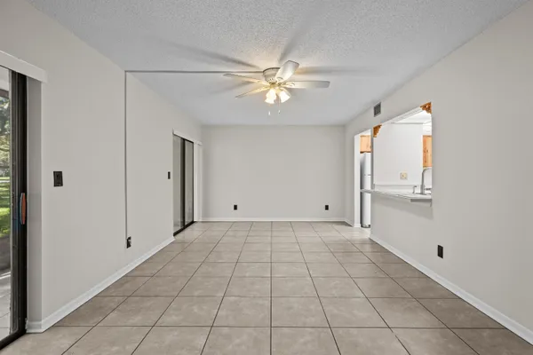 an empty room with windows and fan