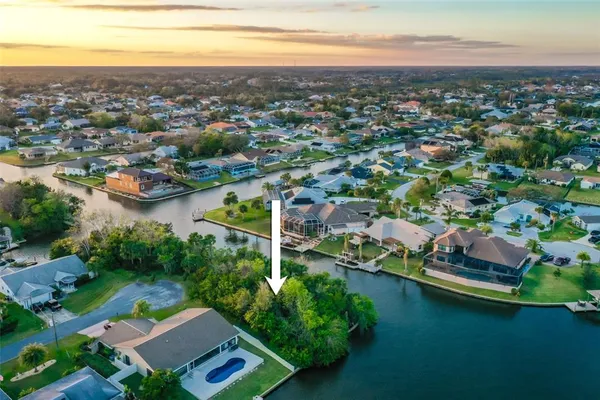 an aerial view of residential house with outdoor space and lake view in back