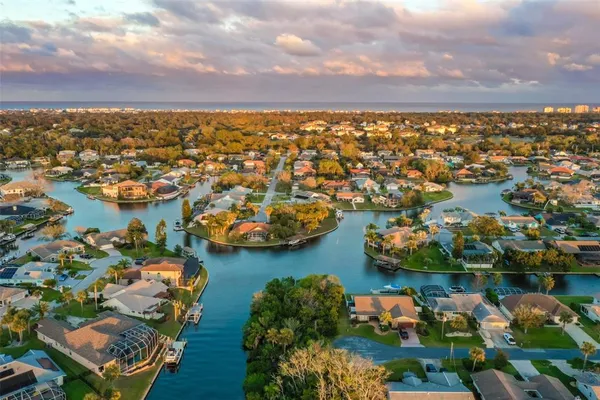 an aerial view of ocean and residential houses with outdoor space
