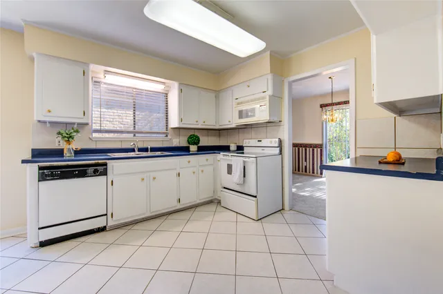 a kitchen with a sink window and cabinets