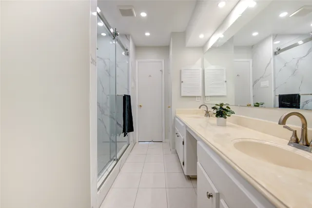 a bathroom with a double vanity sink mirror and shower
