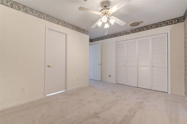 an empty room with chandelier fan