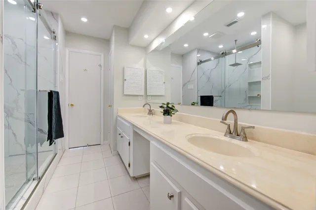 a spacious bathroom with a double vanity sink a mirror and a shower