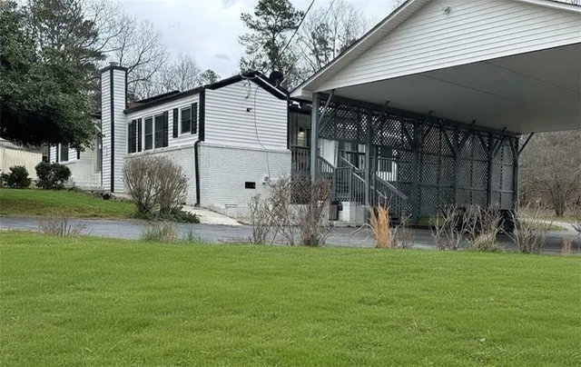 a view of a house with a yard and sitting area
