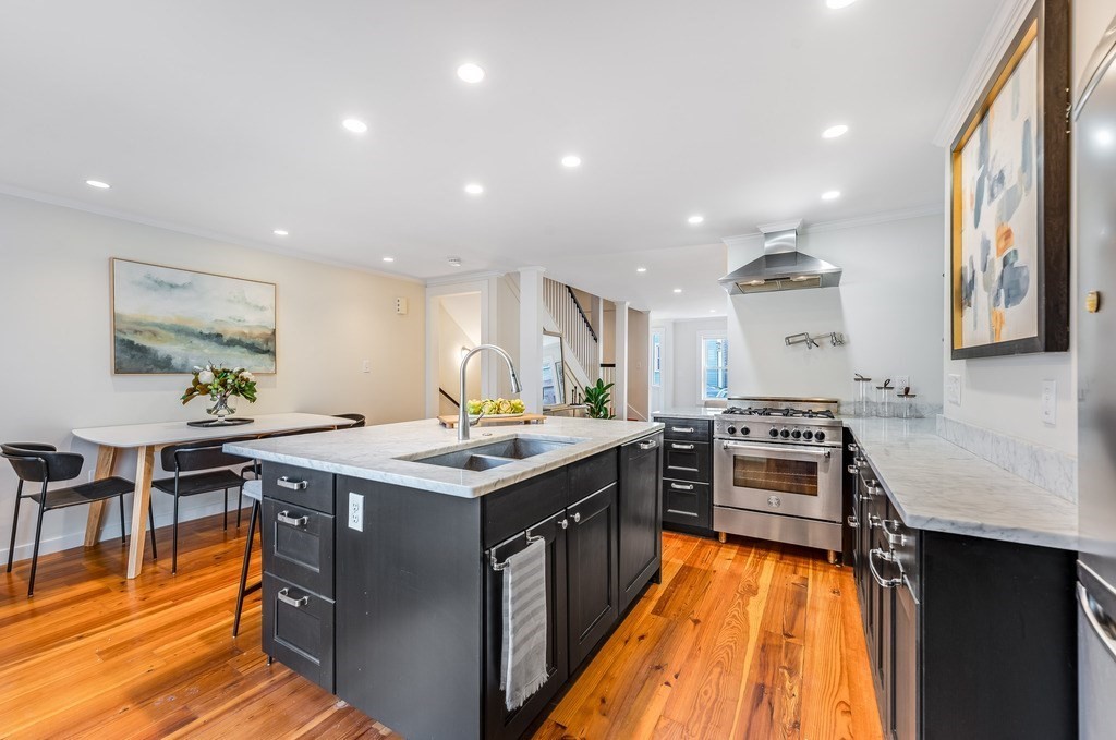 73 Gore Street Cambridge, MA 02141 - Photo 12 of 41 a kitchen with stainless steel appliances granite countertop wooden cabinets stove and sink