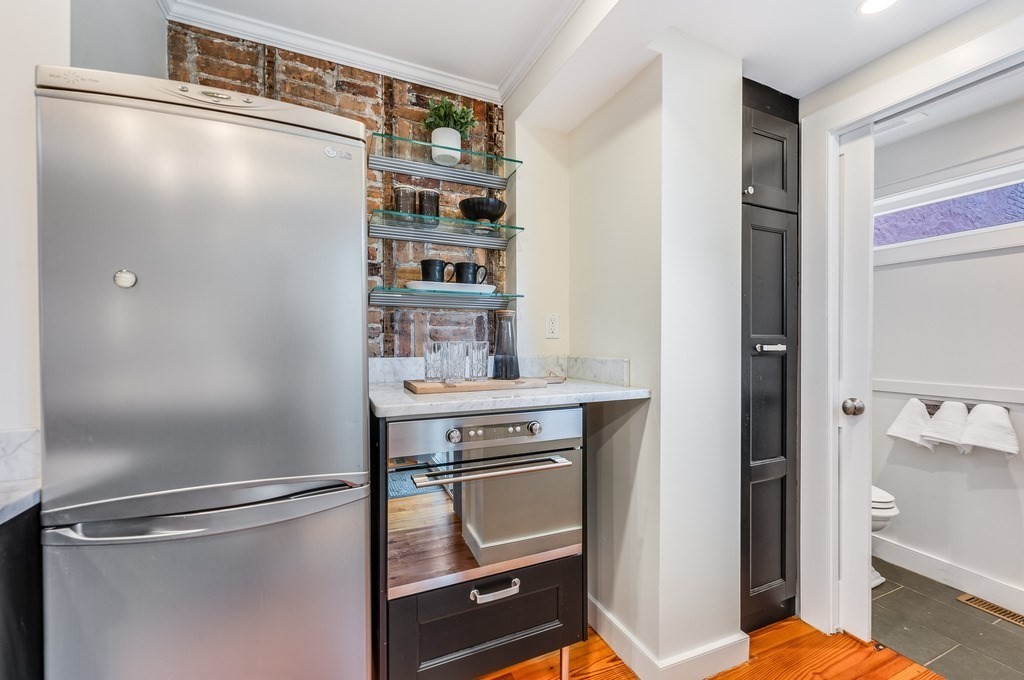 73 Gore Street Cambridge, MA 02141 - Photo 16 of 41 a kitchen with a refrigerator and wooden floor