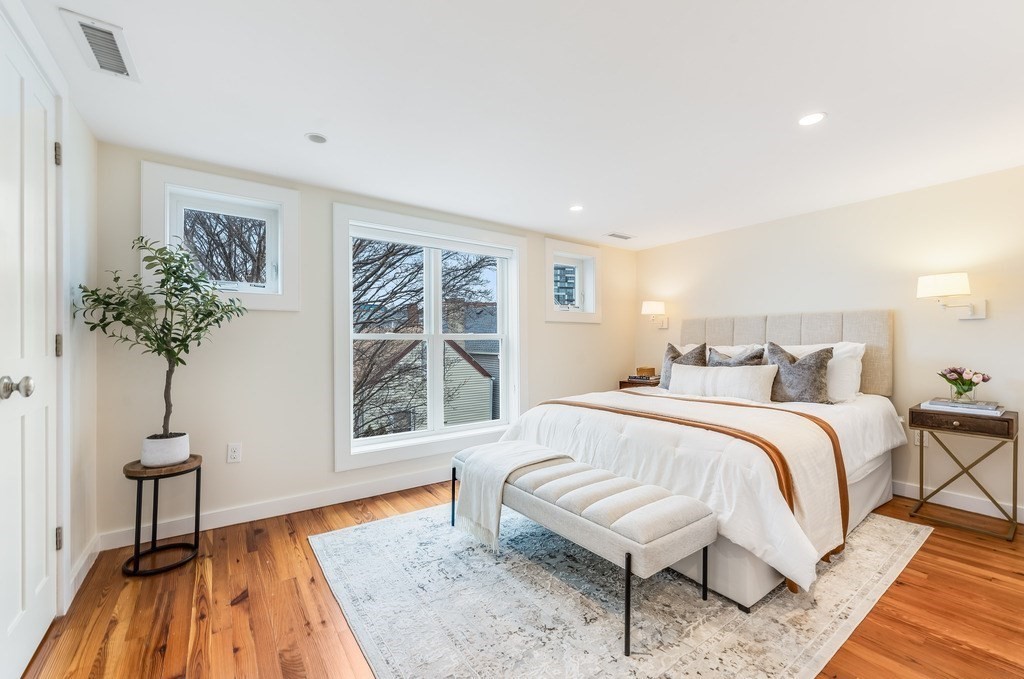 73 Gore Street Cambridge, MA 02141 - Photo 20 of 41 a spacious bedroom with a bed and a table in it