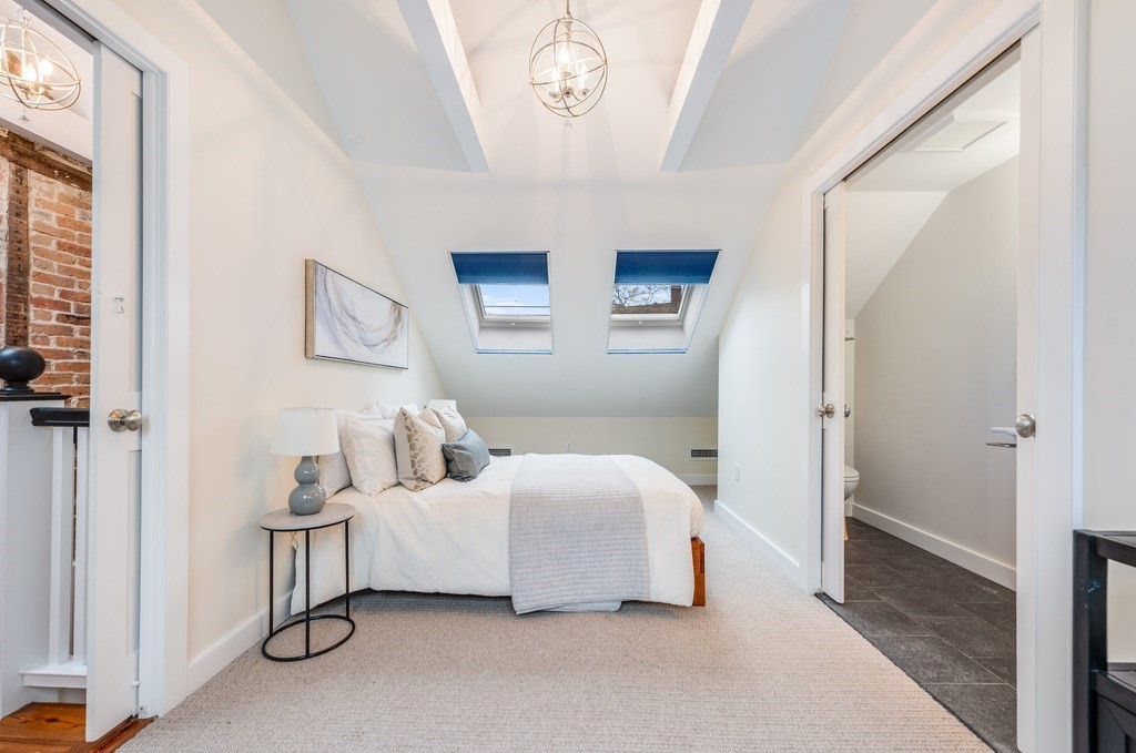 73 Gore Street Cambridge, MA 02141 - Photo 30 of 41 a bedroom with a bed and a chandelier