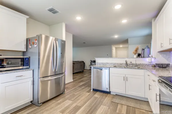 a kitchen with granite countertop a refrigerator stove and sink