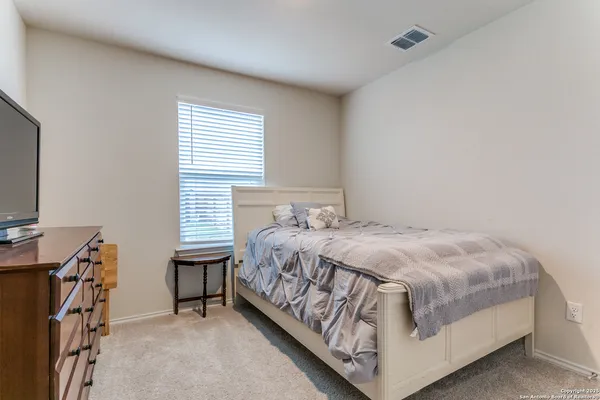 a bed sitting in a bedroom next to a window