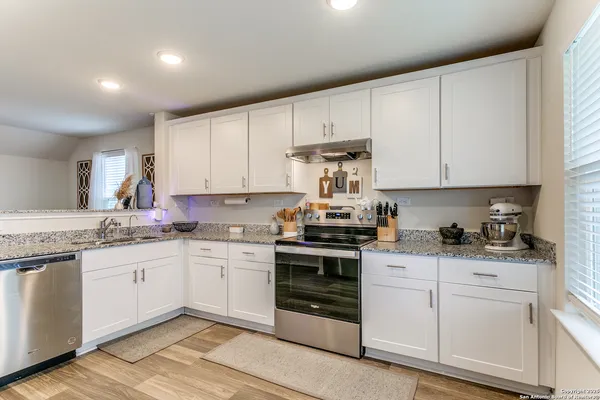 a kitchen with granite countertop white cabinets and white appliances