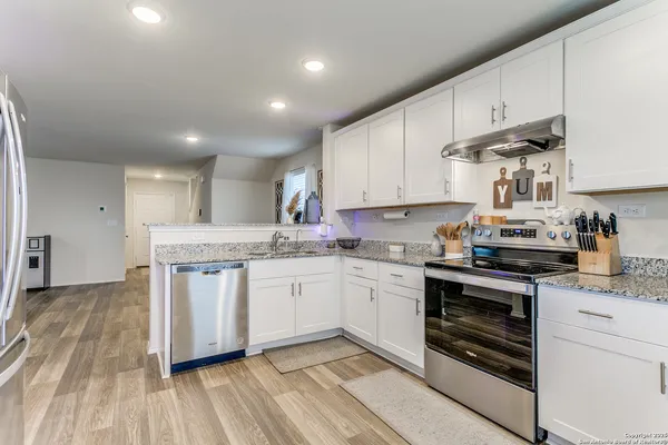 a kitchen with granite countertop cabinets stainless steel appliances and a sink