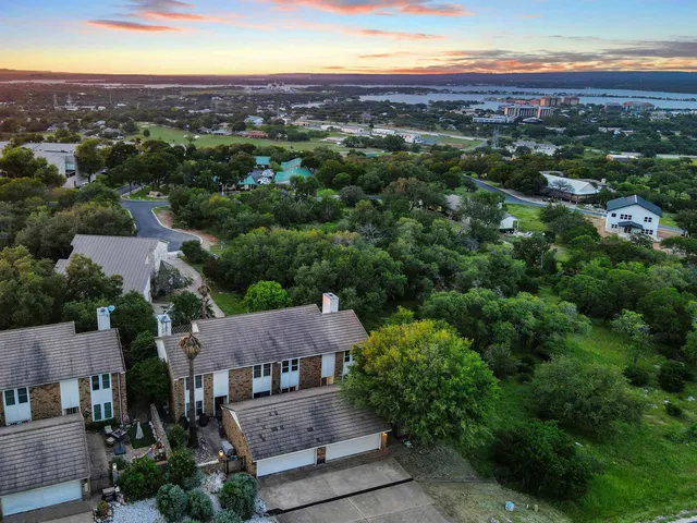 an aerial view of a city with lots of residential buildings and mountain view in back