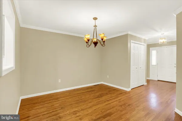 a view of a room with wooden floor chandelier and a window