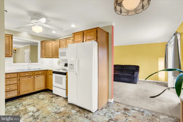 a kitchen with stainless steel appliances granite countertop a refrigerator a sink and white cabinets