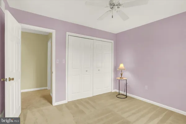 a view of an empty room with a chandelier fan