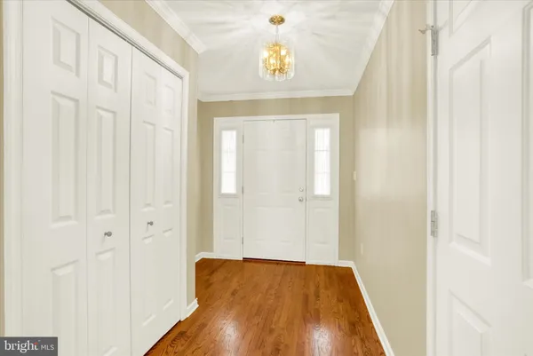 a view of a hallway with wooden floor and a bathroom
