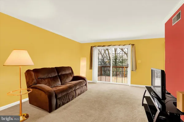 a living room with furniture a flat screen tv and a large window