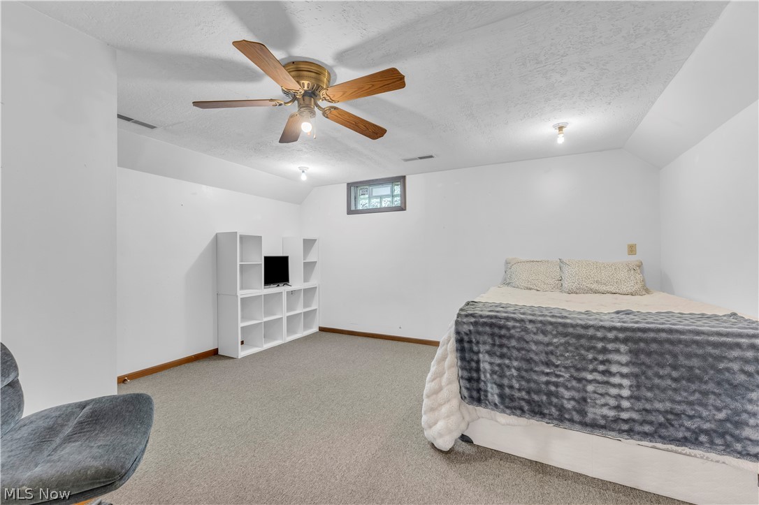 408 River Road Canal Fulton, OH 44614 - Photo 31 of 42 Carpeted room featuring a ceiling fan with wood-finish blades, a built-in shelving unit, and a window providing natural light