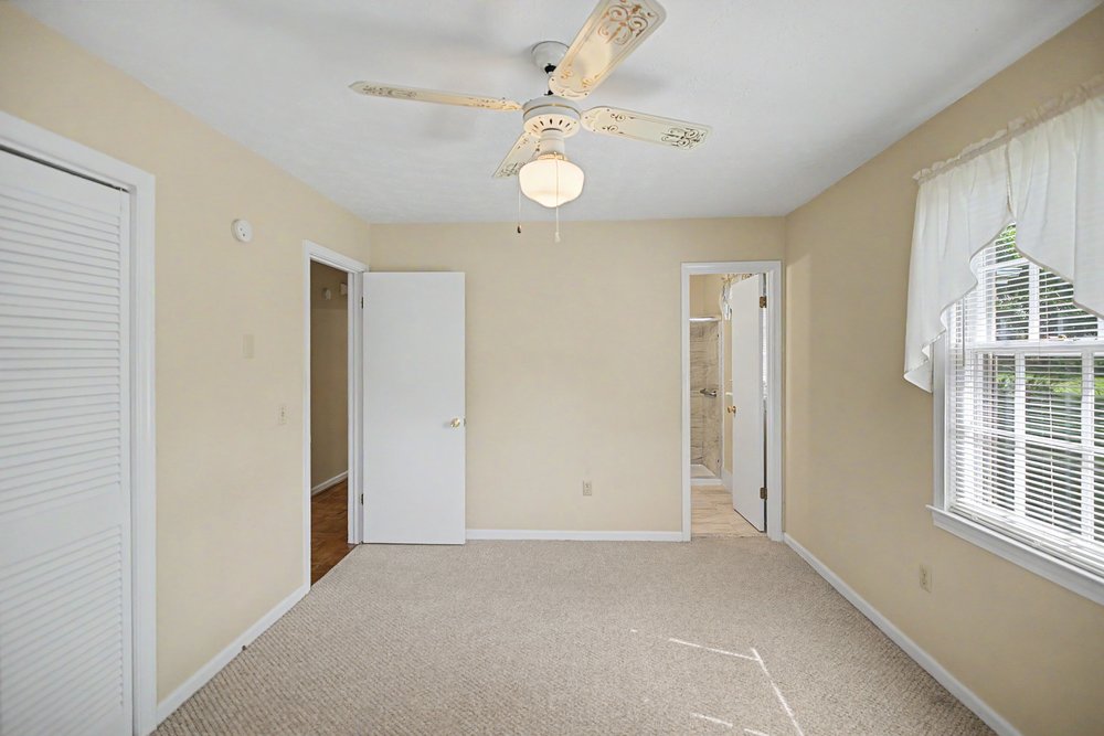 115 Brunson Drive Pickens, SC 29671 - Photo 13 of 29 A well-lit bedroom featuring a classic ceiling fan and plush carpeting.