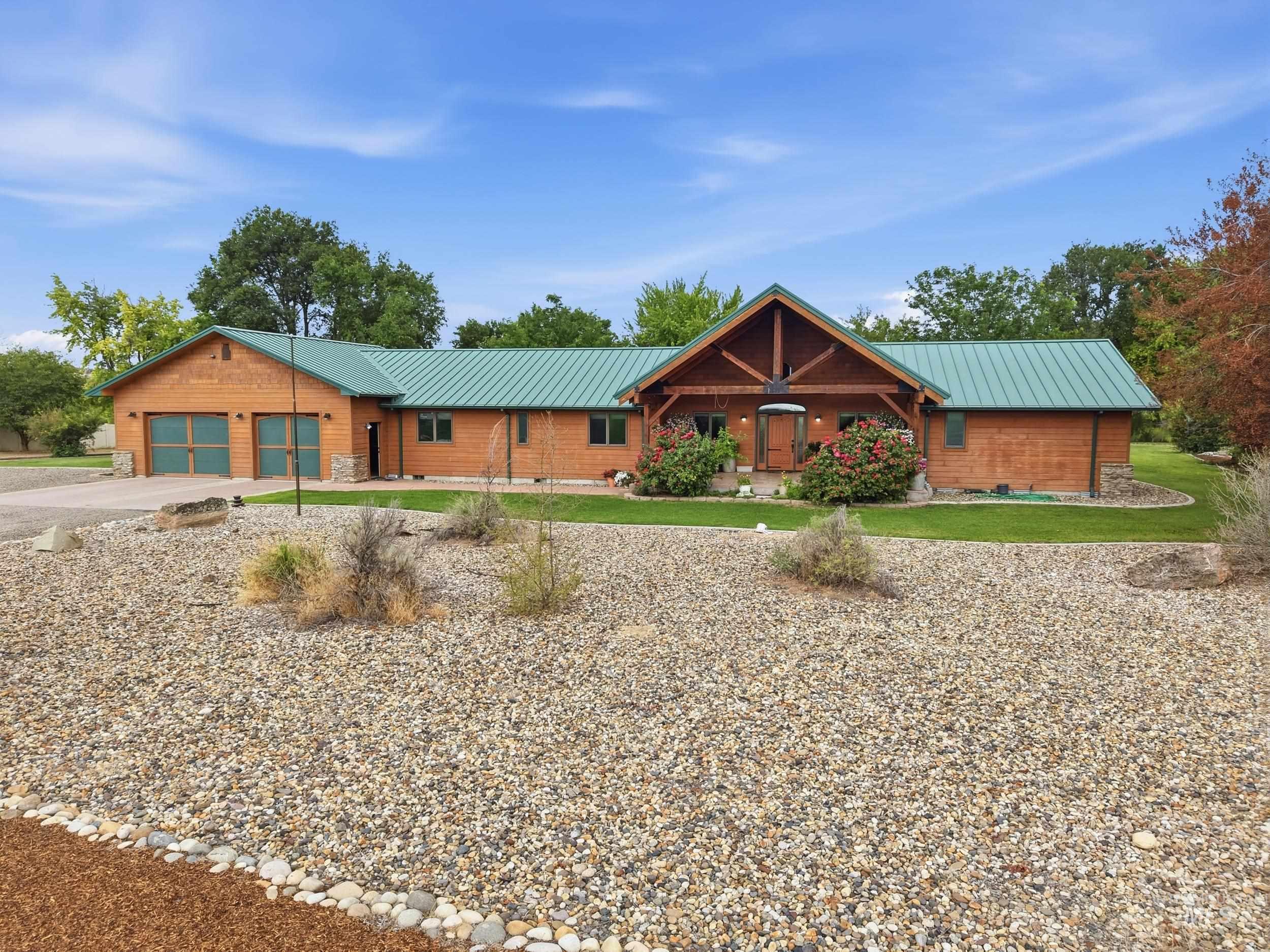339 Airport Road Weiser, ID 83672 - Photo 2 of 49 Expansive wood-sided home featuring a prominent covered entry with exposed timber framing