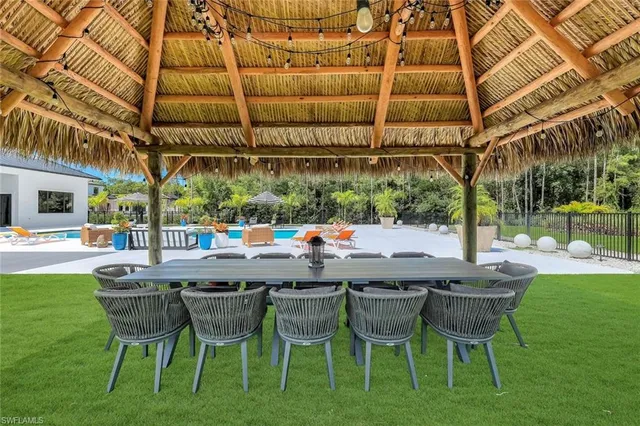 a patio with a table and chairs and a barbeque