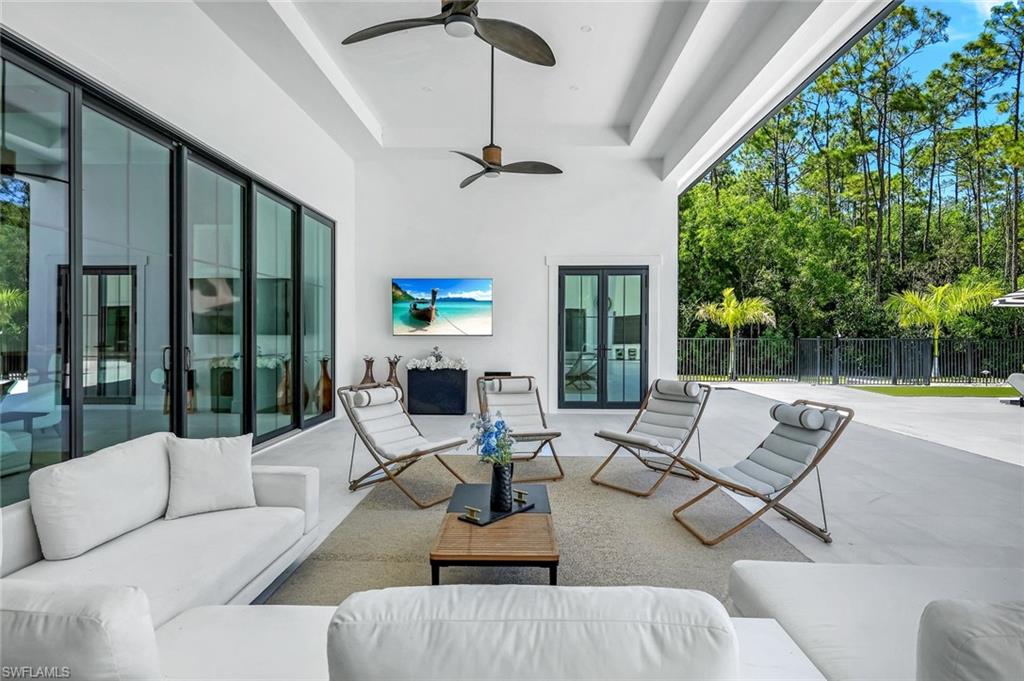 6677 Hunters Road Naples, FL 34109 - Photo 16 of 50 a living room with furniture ceiling fan and a large window