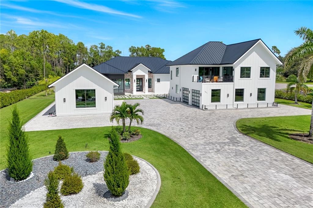 6677 Hunters Road Naples, FL 34109 - Photo 2 of 50 a front view of a house with garden