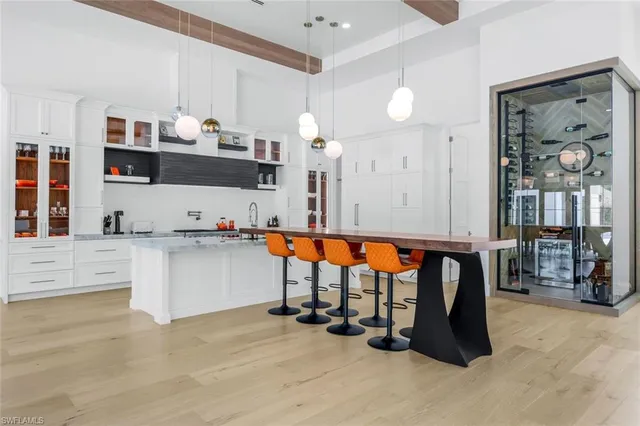 a room with stainless steel appliances kitchen island granite countertop a refrigerator and cabinets