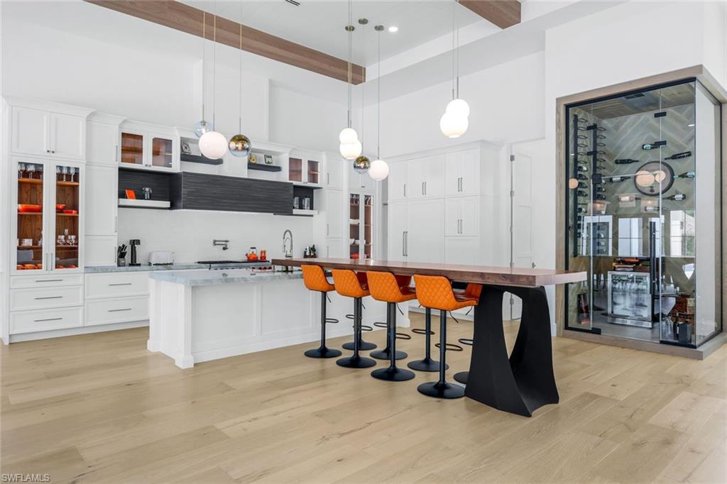6677 Hunters Road Naples, FL 34109 - Photo 22 of 50 a room with stainless steel appliances kitchen island granite countertop a refrigerator and cabinets