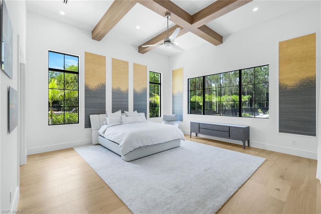 6677 Hunters Road Naples, FL 34109 - Photo 28 of 50 a spacious bedroom with a large bed and a large window