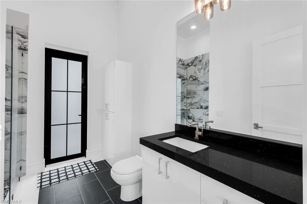 6677 Hunters Road Naples, FL 34109 - Photo 33 of 50 a bathroom with a sink a toilet and shower