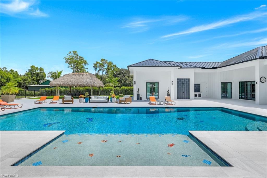6677 Hunters Road Naples, FL 34109 - Photo 34 of 50 a view of swimming pool with outdoor seating and house in the background