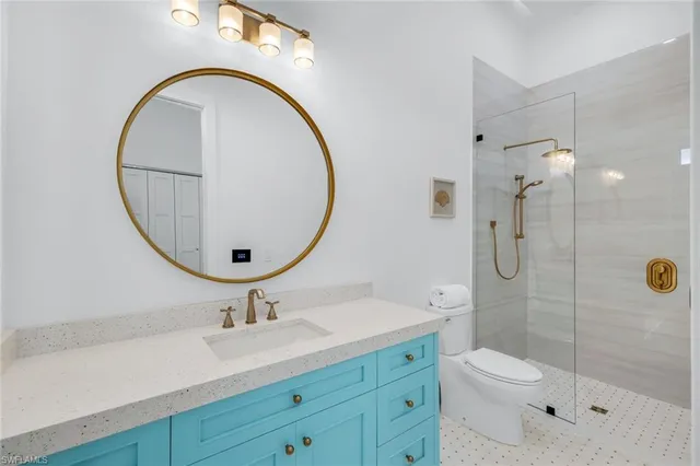 a bathroom with a toilet a sink a mirror and shower